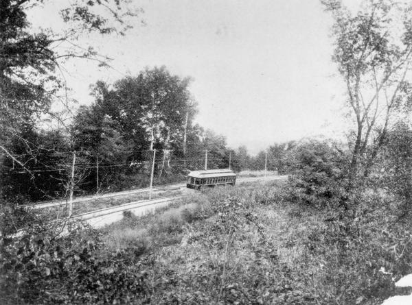 Historic photo of a CL&A car captioned "From gravel pit, looking northwest. The Whitewater River in the distance...Stop No. 122."