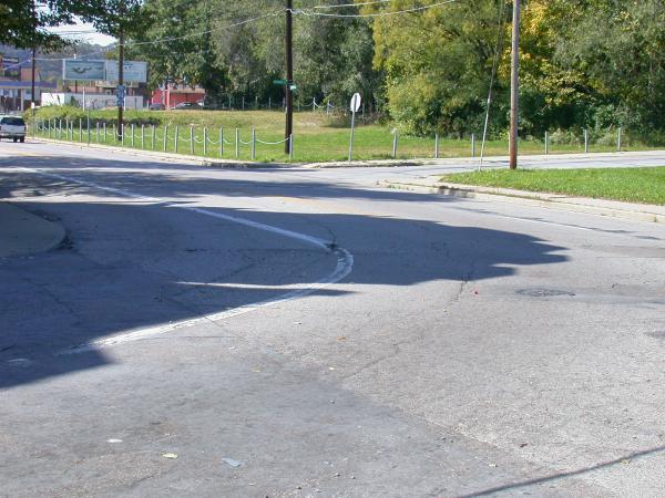 Cracks in the street reveal buried tracks at the corner of Chase and Virginia Avenues in Northside