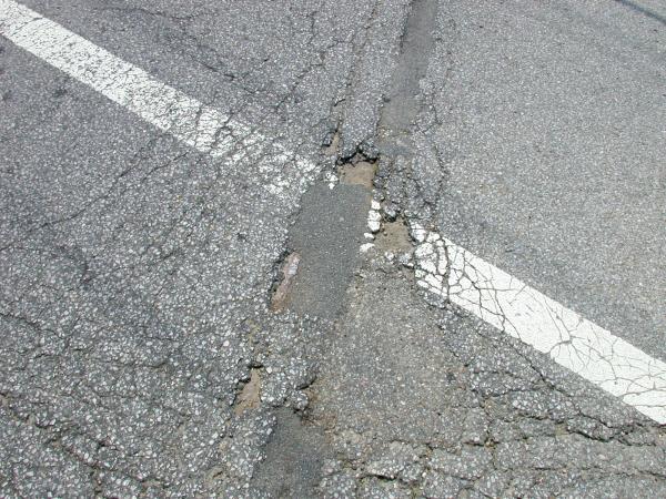Close up of tracks appearing through deteriorated pavement on Ft. Thomas Avenue in Ft. Thomas